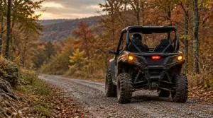 Side-by-side UTV with turn signals and brake light on, driving a gravel county road through Ozark fall forest