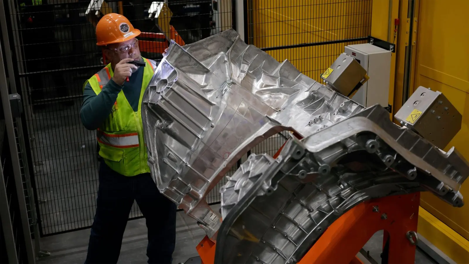 Ford worker inspecting a Fathom aluminum unicasting