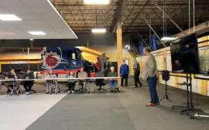 Dennis Geipel, District Sales Manager for Optimus Technologies, addresses attendees at Peaslee Technical Training Center in Lawrence, Kansas, during the October 7 announcement of a new B100 biodiesel technician training program. A heavy-duty truck is disp