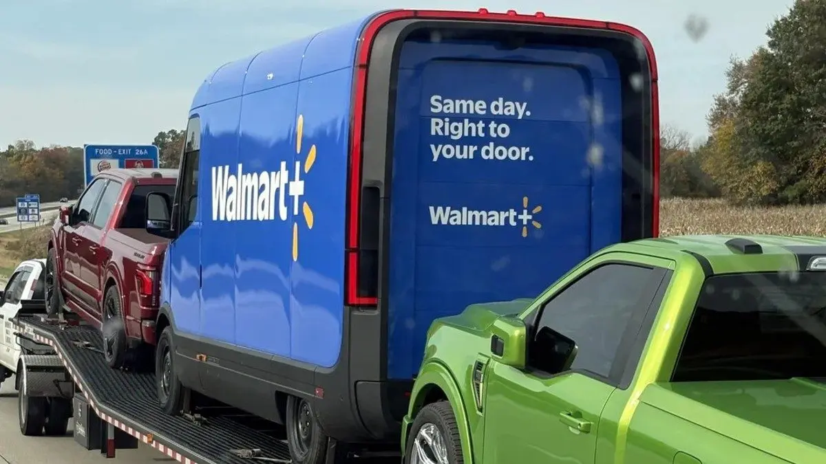 Rivian electric delivery van in Walmart+ livery on a car hauler on I-94 in Indiana