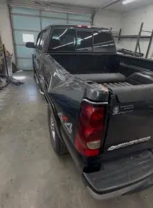 Crumpled rear bed side and corner of a black Chevrolet Silverado pickup before collision repair in Cabot, Arkansas